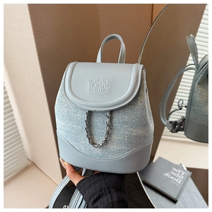 Detail of light blue denim mini backpack with sparkling rhinestones and metal chain buckle