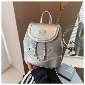 Detail of silver metallic backpack with chain accent and bear embroidery elements