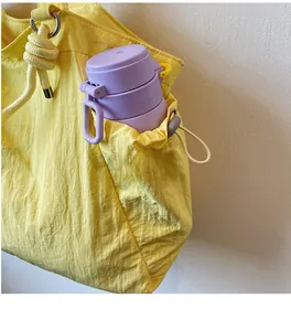 Nylon travel tote detail showing large capacity side pocket with a purple water bottle