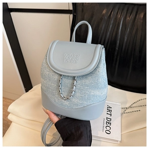 Close-up of light blue patchwork mini backpack with rhinestone decor and silver chain
