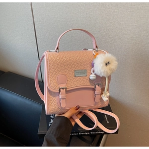 Détail du sac à dos rose en similicuir crocodile avec boucles et porte-clé peluche