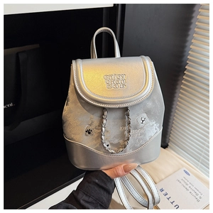 Close-up of a silver metallic mini backpack featuring embroidery and decorative chains