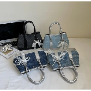 Detail of denim bucket bags with lace bows and pearl charms in four different colors
