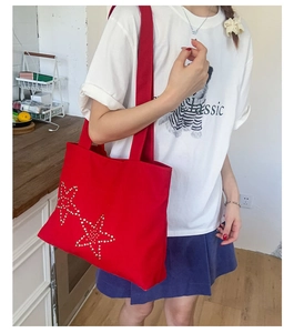 Detail shot of red canvas tote bag with sparkling rhinestone star studs on front