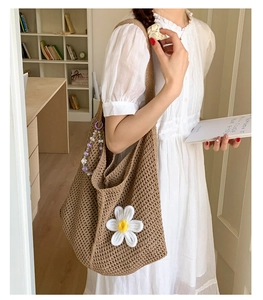 Detail der braunen Web-Tasche mit weißer Gänseblümchen-Verzierung und lila Perlenkette