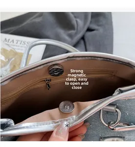 Macro view of silver bucket bag featuring strong magnetic buckle and inner zipper pocket
