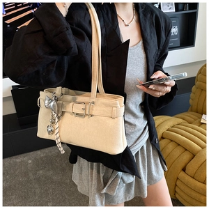 Detail of cream bucket bag with silver heart charm and leather strap buckle