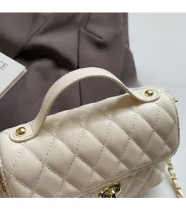 Detailed view of beige quilted leather handbag with golden twist lock and top handle