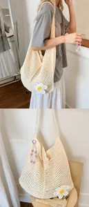 Close-up of cream crochet tote bag featuring white daisy flower and hollow knit texture