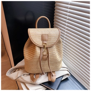 Detail of woven straw backpack showing leather trim and metal clasp closure