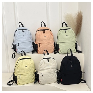 Collection of lightweight nylon backpacks in various pastel colors with a smiley face logo