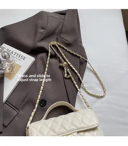 Detail of white quilted leather bag with adjustable gold ball chain strap slider