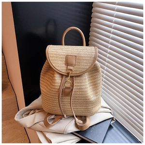 Detail of woven straw backpack with leather drawstring and golden metal buckle closure
