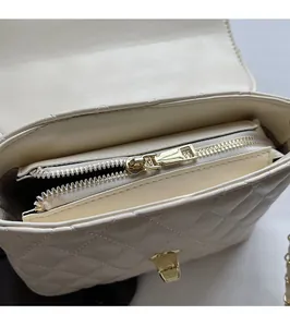 Close-up of the beige quilted handbag interior with a smooth golden metal zipper slider