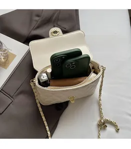 Detailed view of the white quilted crossbody bag capacity with chain strap and gold clasp
