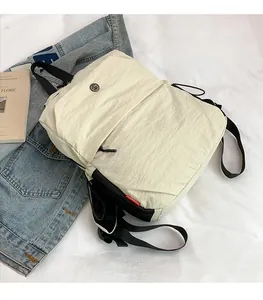 Close-up of off-white casual backpack made of lightweight nylon fabric with red tag detail