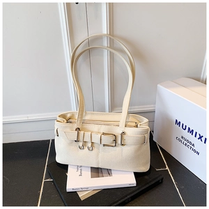 Detailed macro shot of creamy white lychee grain leather handbag with metal buckle