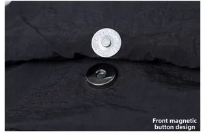 Detailed macro view of magnetic silver snap buckle on textured black fabric backpack