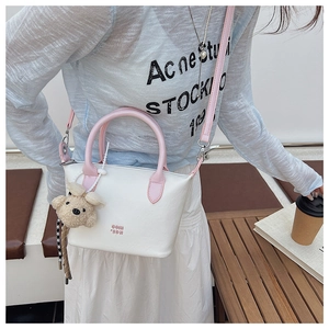 Détail du sac seau blanc avec poignées roses et charmant petit ours en peluche
