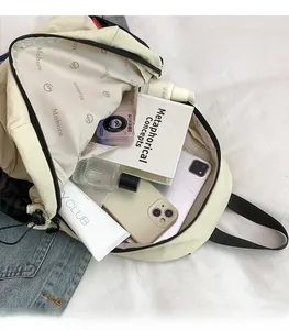 Top view of spacious cream nylon backpack showing books and cosmetics storage inside