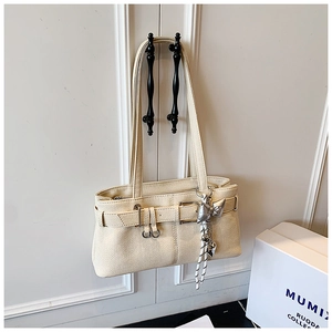 Detail of off-white lychee texture leather bucket bag with silver butterfly charm