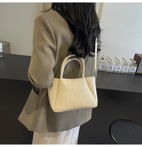 Schicke beige gesteppte Umhängetasche kombiniert mit einem braunen Blazer für Damen