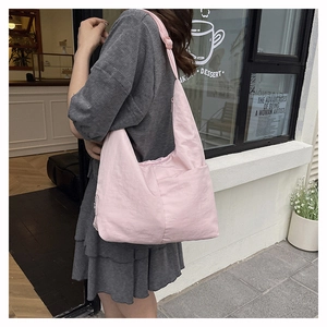 Pink nylon tote bag shown on model featuring large capacity and minimalist casual style