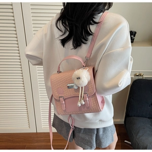 Détail arrière du sac à dos rose avec rabat tressé et charmante peluche suspendue
