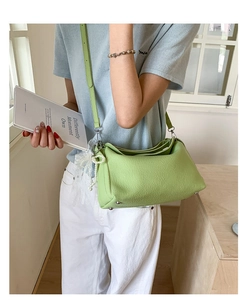 Close-up of light green dumpling bag with lychee texture and pearl lace pendant
