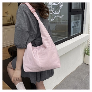 Pink nylon hobo tote bag shown in outdoor street style for a casual commuter look
