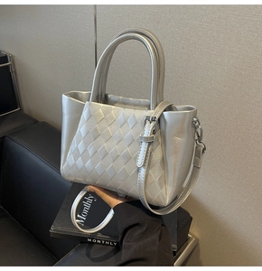 Detailed view of silver quilted bucket bag with metallic finish and dual handles