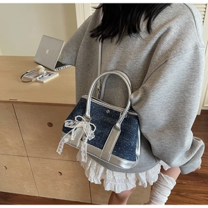 Detail der blauen Denim-Beuteltasche mit silbernen Pailletten, Spitzenschleife und Perle