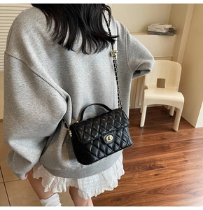 Quilted black leather handbag with gold chain strap shown on model for size and style