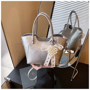 Detail of silver bucket bag with metallic crinkle texture and pearl heart charm decor