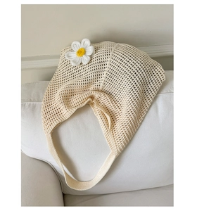 Nahaufnahme einer cremefarbenen Häkeltasche mit 3D-Gänseblümchen und Lochmuster-Textur