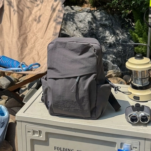 Detailed view of the dark grey waterproof nylon outdoor backpack with multi-pocket design