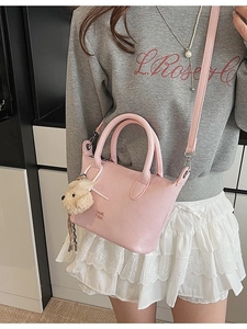 Sac seau rose avec pendentif ours en peluche, porté par un mannequin à la maison