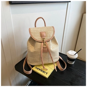 Dettaglio zaino in paglia intrecciata con patta in ecopelle rosa e coulisse