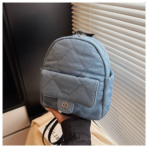Close-up of blue denim mini backpack with quilted pattern and metal turn-lock detail