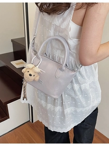 Sac seau bandoulière violet clair avec breloque ours en peluche porté par un mannequin