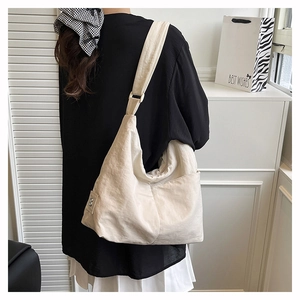 Detail of off-white large capacity hobo bag with wide shoulder strap on model