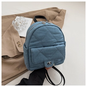 Detail of blue denim quilted mini backpack with silver zipper and metal twist lock