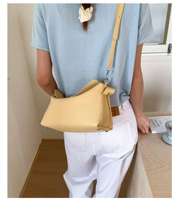 Detail of yellow lychee leather dumpling bag showing silver buckles and shoulder strap