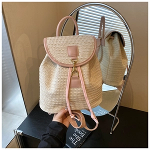 Detail of woven straw backpack with pink faux leather flap and drawstrings