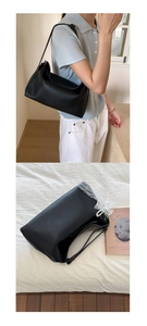 Detail of black lychee leather bag featuring white lace and pearl chain decoration