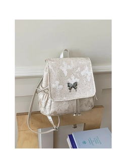 Détail du tissu jacquard à papillons blancs et du fermoir en métal argenté du sac à dos