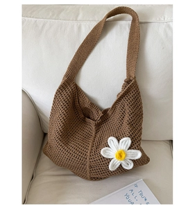 Detailansicht einer dunkelbraunen Häkeltasche mit weißer gestrickter 3D-Gänseblümchenblüte