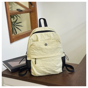 Detail of light yellow textured fabric backpack with front pocket and side mesh storage