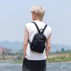 Outdoor shot showing the adjustable straps and side drawstring pocket of this black backpack