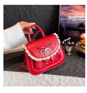 Dettaglio dello zaino in pelle PU rossa con bordo in pizzo bianco e fiocchi decorativi